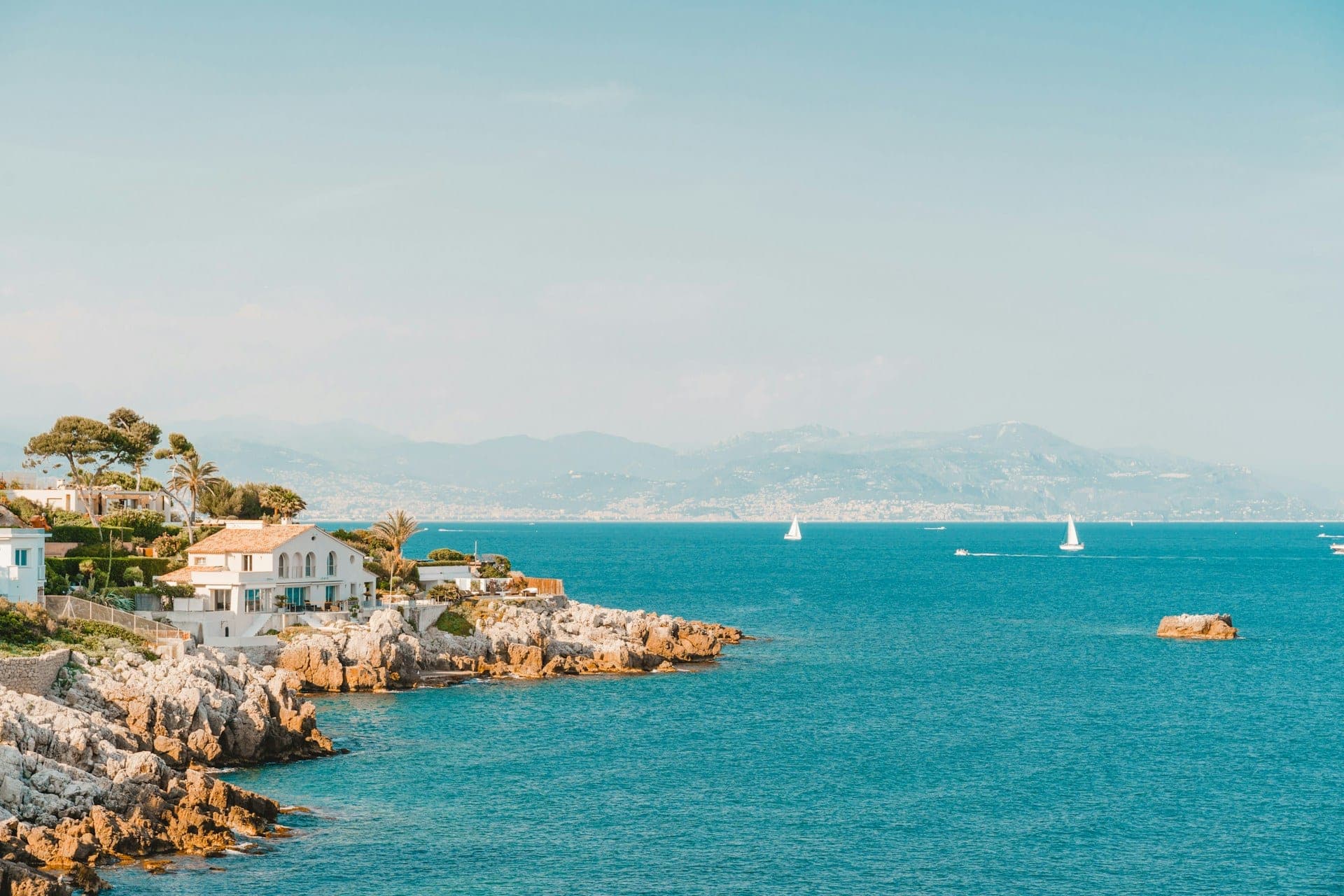 Le littoral d’Antibes, ses maisons au bord des rochers et des voiliers en Méditerranée.