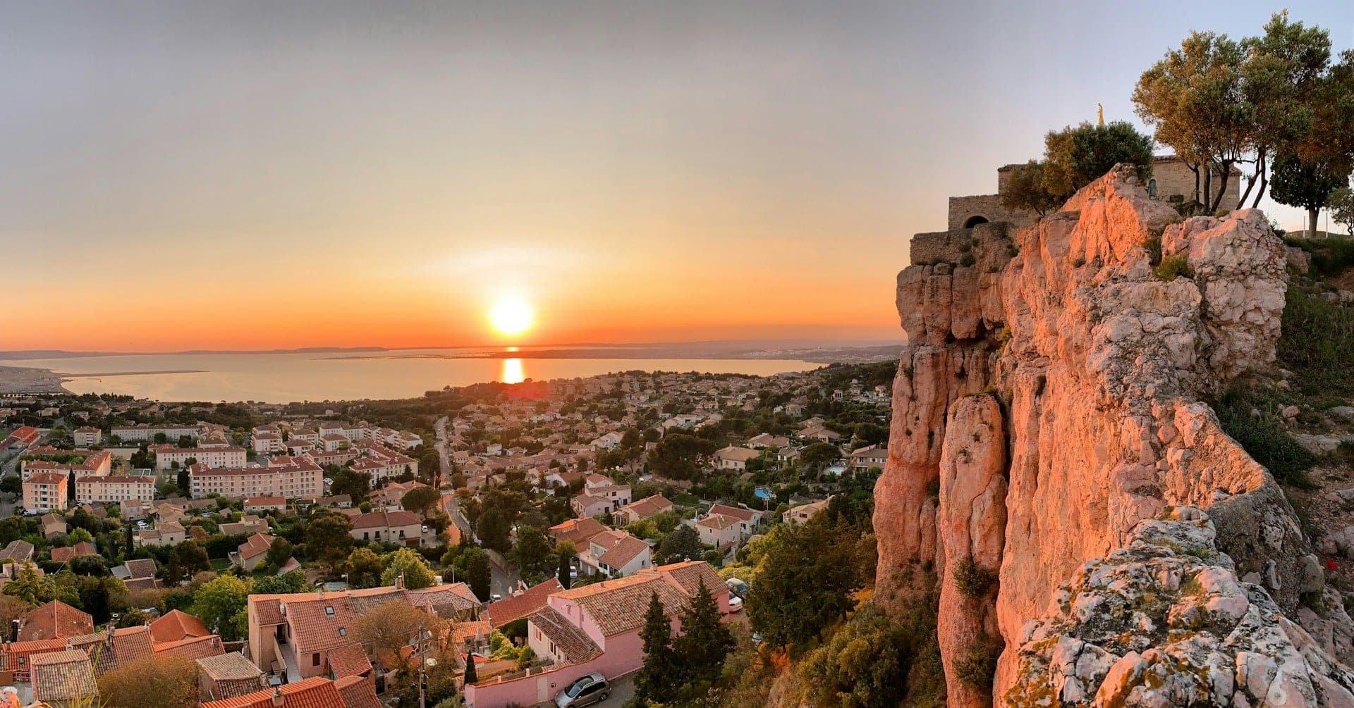 Le rocher de Vitrolles au coucher du soleil, au-dessus de la ville et de l’étang de Berre.